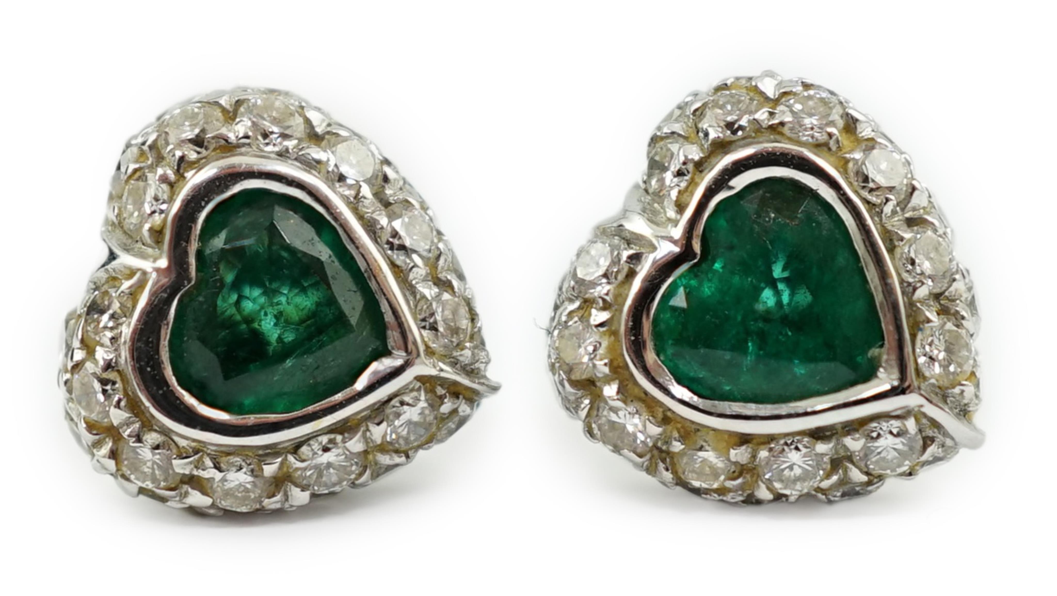 A modern pair of 18ct white gold, emerald and diamond set heart shaped cluster ear studs